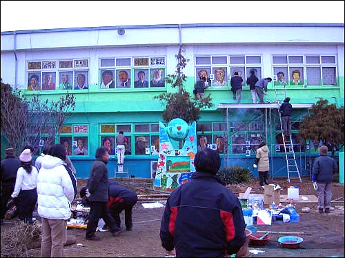 평택 대추초등학교 유리창과 벽면에 그림 작업 중인 미술가들. 48개 유리창에 48명의 주민 얼굴을 그렸다. 